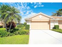 Inviting one-story home features a lush landscaped front yard with a private two-car garage at 362 Fairway Isles Ln, Bradenton, FL 34212