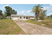 Charming single-story home features a driveway, lush lawn and a mature palm tree at 4330 Alligator Dr, Venice, FL 34293