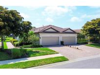 Beautiful home with a brick driveway, well-manicured lawn, and a two-car garage at 5863 Cavano Dr, Sarasota, FL 34231