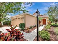Charming one-story home featuring a manicured front yard with colorful landscaping and a cozy, inviting entrance at 6352 Robin Cv, Lakewood Ranch, FL 34202