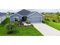 Charming single Gathering home featuring a two-car garage and a beautifully landscaped front yard at 6435 165Th E Dr, Parrish, FL 34219