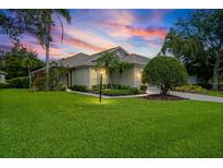 Charming single-story home featuring a well-manicured lawn, mature landscaping, and inviting curb appeal at 7424 Sea Island Ln, Bradenton, FL 34201