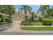 Charming single-story home boasts mature landscaping, a tile roof, and a brick driveway at 7717 Us Open Loop, Lakewood Ranch, FL 34202