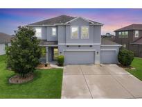 Beautiful two-story home featuring a three-car garage and manicured lawn at 7930 111Th Ter E, Parrish, FL 34219