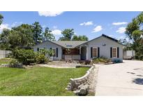 Charming single-story home with well-manicured lawn and stone accents on a sunny day at 9007 63Rd Avenue E Dr, Bradenton, FL 34202