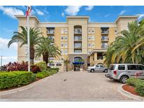Beautiful building with palm trees and mature landscaping under a bright blue sky on a sunny day at 1064 N Tamiami Trl # 1125, Sarasota, FL 34236