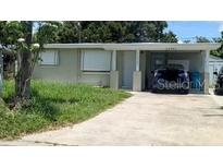 Charming single-story home with a covered parking area, a well-maintained lawn, and mature trees at 11707 104Th St, Largo, FL 33773