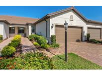 Charming home with a two-car garage, brick driveway, and well-maintained landscaping at 17612 Northwood St, Lakewood Ranch, FL 34202