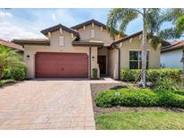 Charming single-Gathering home featuring a red brick driveway, two-car garage, and lush tropical landscaping at 201 Vinadio Blvd, Nokomis, FL 34275