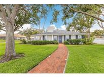Charming single-story home with a brick walkway and a well-manicured lawn at 2401 Riverview Blvd, Bradenton, FL 34205