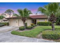 Charming single-story home featuring a well-manicured lawn, mature palm trees, and a two-car garage at 3617 Yellow Pine Ct # 144, Sarasota, FL 34238