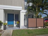Inviting condo exterior with a bright blue door, neutral siding, privacy fence, and lush landscaping at 4001 Beneva Rd # 319, Sarasota, FL 34233