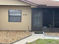 Tan home exterior featuring well-maintained landscaping and a clearly visible house number at 4199 66Th Street W Cir # 4199, Bradenton, FL 34209