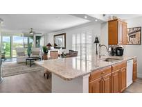 Bright kitchen featuring granite countertops, stainless sink and appliances, and open to a stylishly furnished living area at 4440 Fairways Blvd # 310, Bradenton, FL 34209