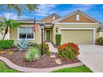 Charming single-story home featuring colorful landscaping, a well-manicured lawn, and an attached two-car garage at 5005 Torrey Pines Run, Bradenton, FL 34211
