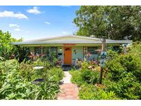 Charming home featuring an orange door and vibrant garden, a welcoming entrance at 5317 14Th S Ave, Gulfport, FL 33707