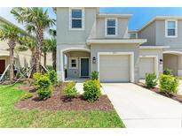 Charming two-story townhome with a one car garage, landscaping, and a welcoming front entrance at 5711 Archipelago St, Nokomis, FL 34275