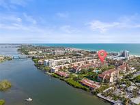 Beautiful aerial view of a waterfront condo community near the ocean under a bright, blue sky at 6265 Midnight Pass Rd # 205, Sarasota, FL 34242