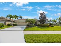 Charming single-story home with a manicured lawn, mature palm trees, and a spacious driveway at 7615 Charleston St, Bradenton, FL 34201