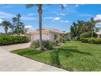 Charming single-story home with a well-manicured lawn, lush landscaping, and a welcoming two-car garage on a sunny day at 13391 Dimarco St, Venice, FL 34293