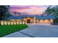Stunning exterior view of a modern home featuring a two-car garage, a secure gate, and lush landscaping at 1627 Peregrine Point Ct, Sarasota, FL 34231