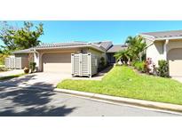 Charming single-story home with a well-manicured lawn, tile roof, and two-car garage at 2103 Harbourside Dr # 1102, Longboat Key, FL 34228