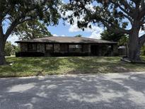 Charming stone-faced home with mature trees and a well-maintained front yard at 211 55Th Nw St, Bradenton, FL 34209