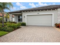 Attractive home featuring a two car garage, paver driveway and lush landscaping at 2316 Springhaven Ln, Lakewood Ranch, FL 34211