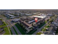 Aerial view of a complex with covered parking, green spaces, and easy access to nearby amenities at 2395 Harbor Blvd # 314, Port Charlotte, FL 33952