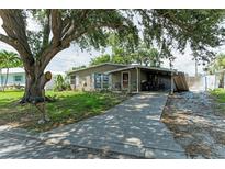 Charming single-story home featuring a covered porch and driveway under a large tree canopy at 3307 Miami Pl, Bradenton, FL 34207