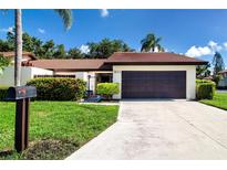 Charming single-story home featuring a well-manicured lawn, tile roof, and attached two-car garage at 3615 Puerta Ct # 8516, Sarasota, FL 34232