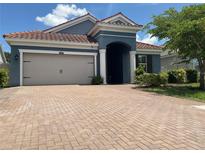 Charming single-story home with a brick driveway, two-car garage, and a terracotta roof at 4428 Conchfish Ln, Osprey, FL 34229