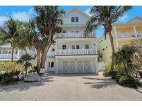 Charming multi-story beach house with dual balconies, garage, and tropical landscaping at 538 Canal Rd, Sarasota, FL 34242