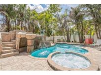 Tropical pool area features a waterfall feature, hot tub, and lush landscaping at 538 Canal Rd, Sarasota, FL 34242