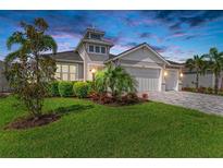 Charming home featuring well-manicured lawn, lush landscaping, and a three-car garage at 5428 Title Row Dr, Bradenton, FL 34210