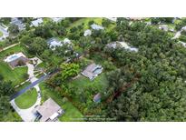 Aerial view showing the home with a large lot surrounded by mature trees in a quiet neighborhood at 5430 Richardson Rd, Sarasota, FL 34232