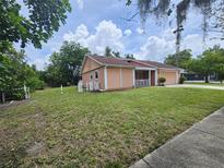 Side view of home with a lush lawn, white picket fence, and mature trees at 6305 Bikini Rd, Sarasota, FL 34241