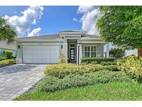 Charming single-story home with a meticulously landscaped front yard and a brick driveway at 7983 Sandstar Way, Sarasota, FL 34240