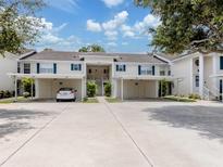 A charming condo building features a carport and stairways to the second floor, with lush landscaping around the building at 821 Montrose Dr # 103, Venice, FL 34293