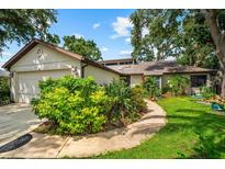 Charming single-story home featuring lush landscaping and a welcoming walkway leading to the front entrance at 8240 Cypress Lake Dr, Sarasota, FL 34243