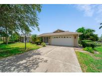 Charming single-story home with a well-manicured lawn and a two-car garage, offering curb appeal at 1299 Tripoli, North Port, FL 34286