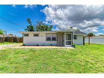 Charming single-story home features a well-maintained lawn, neutral siding and a cozy screened entrance at 2026 Arkansas Ave, Englewood, FL 34224