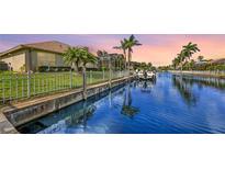 Beautiful waterfront home featuring lush landscaping, a private dock, and picturesque sunset views over the serene canal at 4735 Starboard Dr, Bradenton, FL 34208