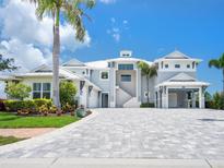 Stunning coastal home featuring a light gray exterior, white trim, and a spacious paved driveway at 5630 Inspiration Ter, Bradenton, FL 34210
