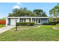 Charming single-story home features a well-manicured lawn, a sunny yellow front door, and an attached one-car garage at 5685 36Th N Ave, St Petersburg, FL 33710