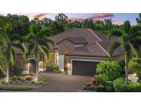 Beautiful home with a well-manicured lawn, tile roof, and mature landscaping at 7628 Haddington Cv, Lakewood Ranch, FL 34202