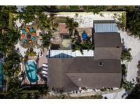A serene aerial view reveals a private pool, verdant landscaping, and a cozy outdoor lounge area of the home at 8709 9Th Nw Ave, Bradenton, FL 34209