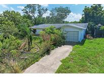 Quaint single-story home featuring an attached garage and mature landscaping at 10095 Nassau Ct, Seminole, FL 33776