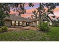 Charming stone home featuring lush landscaping and a welcoming facade at sunset at 1509 Shadow Ridge Cir, Sarasota, FL 34240