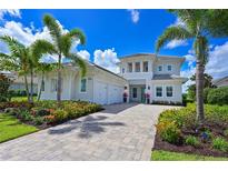 Beautiful two-story home with a paver driveway, lush landscaping, and a three-car garage at 17110 Verona Pl, Bradenton, FL 34202